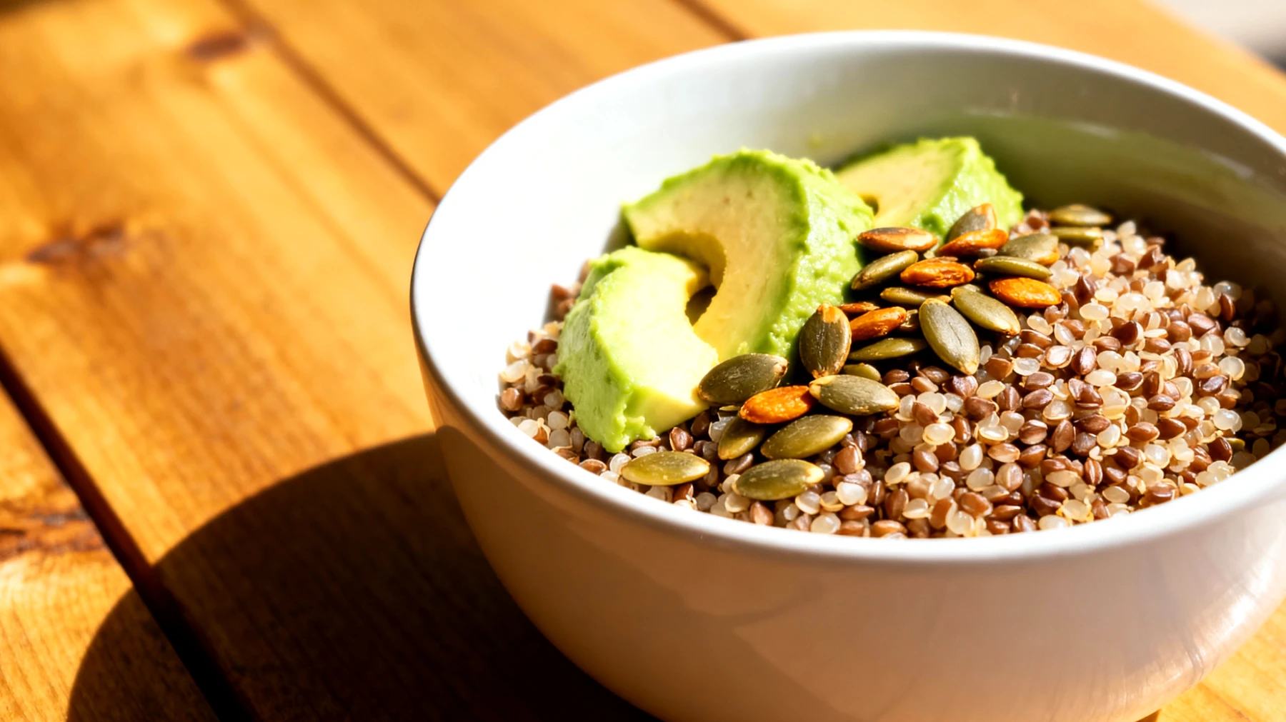 Quinoa-Buchweizen-Bowl mit gerösteten Kürbiskernen und Avocado"